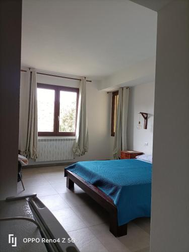a bedroom with a blue bed and a window at B&B Il melograno in Capoterra
