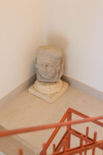 a stone statue sitting in a corner of a room at Agriturismo Ai Tre Sentieri in Aurisina