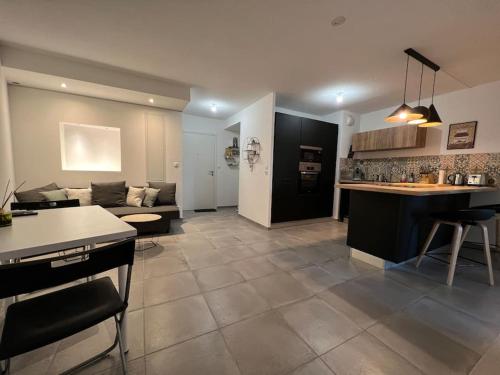 Il comprend un grand salon avec un canapé et une cuisine. dans l'établissement Appt à 10 min de la place comédie Montpellier, à Castelnau-le-Lez