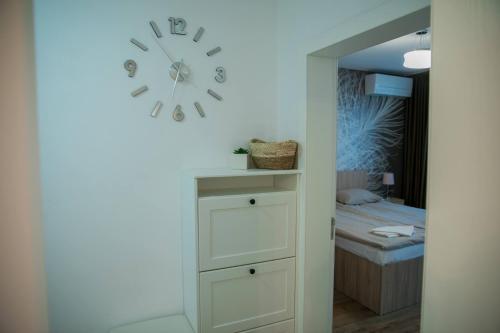a clock on a wall above a dresser in a bedroom at VARNA SEA VIEW Apartment in Varna City