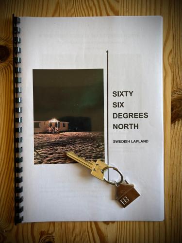a book with a pair of keys on top of it at Sixty Six Degrees North - Lapland Home & Forest in Överkalix