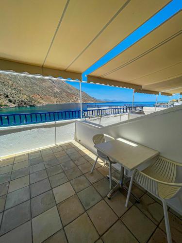 a patio with a table and chairs on a roof at The Blue House in Loutro