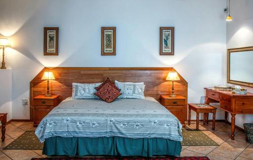 a bedroom with a bed with two night stands and a desk at Suman niwas in Darbhanga