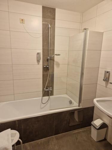 La salle de bains est pourvue d'une douche, d'une baignoire et d'un lavabo. dans l'établissement Dolomitenhotel Lienz, à Lienz
