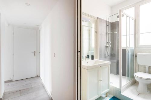 une salle de bain blanche avec des toilettes et un lavabo dans l'établissement Appartement lumineux et calme proche de PARIS, à Vitry-sur-Seine