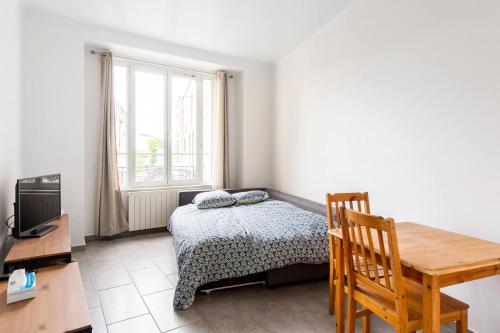 une chambre avec un lit, une table et un bureau dans l'établissement Appartement lumineux et calme proche de PARIS, à Vitry-sur-Seine