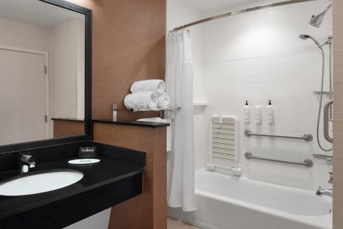 een badkamer met een wastafel, een bad en een douche bij Fairfield Inn & Suites by Marriott Orlando Kissimmee/Celebration in Orlando