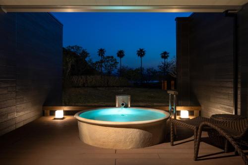 a bath tub in a room with a blue light at Hotel Tokinoza in Kihokucho