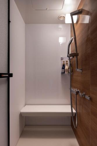 a bathroom with a bench next to a shower at Hotel Tokinoza in Kihokucho