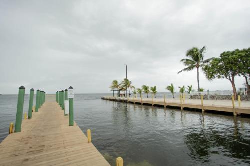 a wooden pier with palm trees and a beach at Kings Kamp in Key Largo