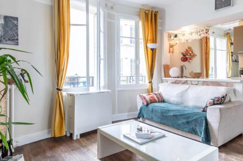 un salon avec un canapé et une table dans l'établissement Enchanting Paris Apartment, à Paris