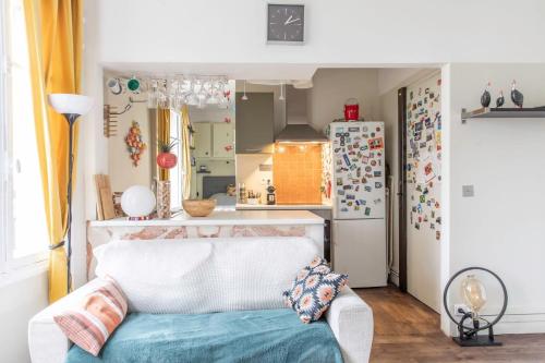 un salon avec un canapé blanc et une cuisine dans l'établissement Enchanting Paris Apartment, à Paris