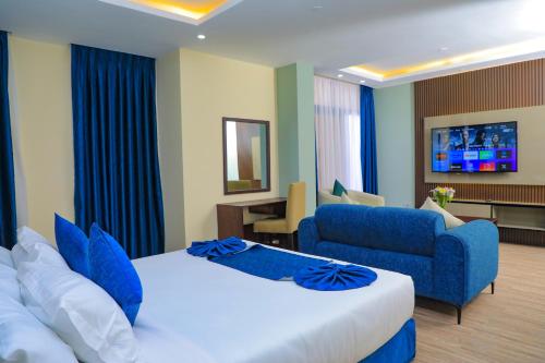 pokój hotelowy z łóżkiem i niebieską kanapą w obiekcie Messay Hotel w Addis Abebie