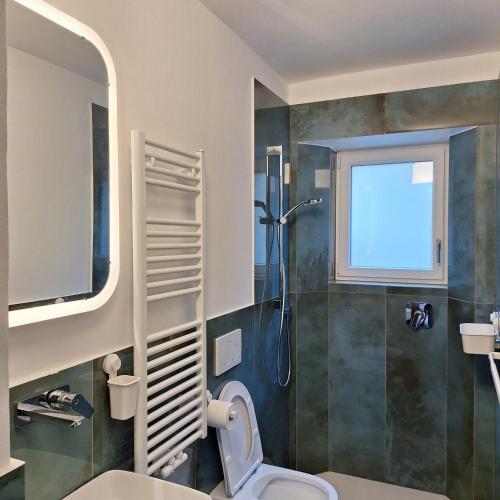 a bathroom with a shower and a toilet and a window at Chalet Center Pic in Ortisei