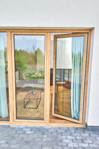 a room with a sliding glass door with a table at Babichy 29 DOM Apartamenty MANDORIA , Rodzina , Family , Orientarium , PTAK , Parking bezpłatny in Babichy