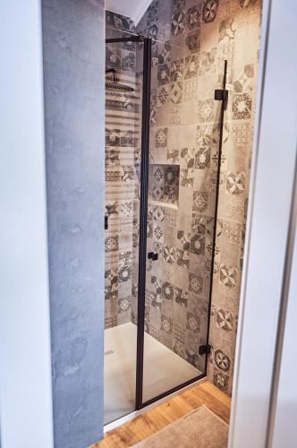 a shower with a glass door in a bathroom at Babichy 29 DOM Apartamenty MANDORIA , Rodzina , Family , Orientarium , PTAK , Parking bezpłatny in Babichy