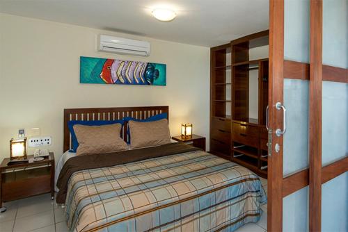 a bedroom with a bed and a dresser at Blue Marlin Apartaments Ponta Negra-Natal-RN in Natal