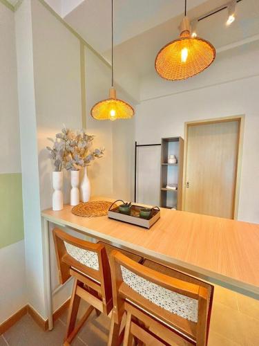 a dining room table with two chairs and two lights at imperium residence kuantan in Kuantan