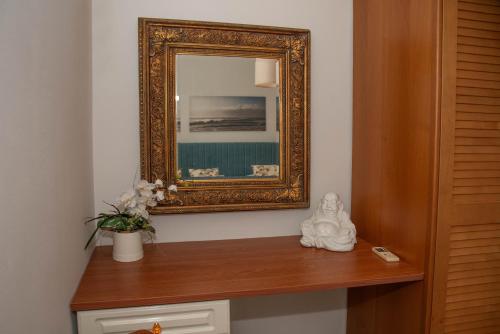 a mirror on a wall next to a table with a vase at TheasHomly in Kastanéa