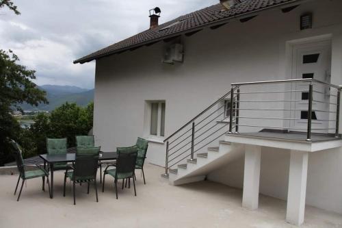 a patio with a table and chairs on a house at Apartmani Venecia in Prozor