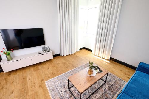 a living room with a tv and a table at Babichy 29 DOM Apartamenty MANDORIA , Rodzina , Family , Orientarium , PTAK , Parking bezpłatny in Babichy