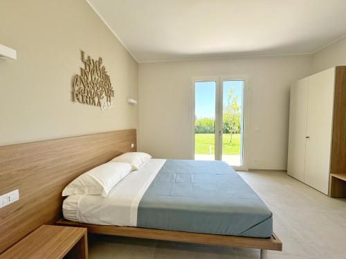 een slaapkamer met een groot bed en een groot raam bij Terra Home Resort in Spongano