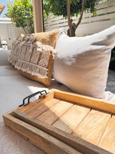 a wooden tray on a table with two pillows at Petite Fleur in Preveza