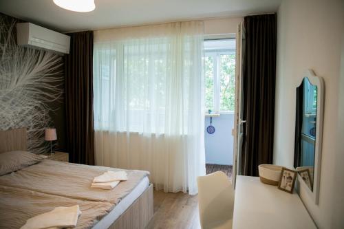 a bedroom with a bed and a window at VARNA SEA VIEW Apartment in Varna City