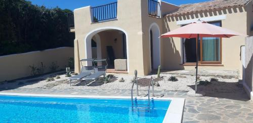a house with an umbrella and a swimming pool at Casa Logos Stintino - Private pool in Stintino
