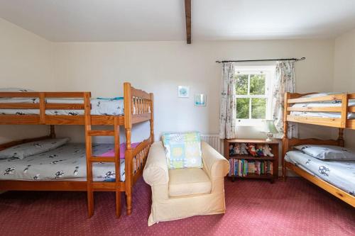 a room with two bunk beds and a chair at Swallows’ Barn in Durham