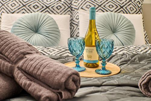 a bottle of wine and two glasses on a bed at Babichy 29 DOM Apartamenty MANDORIA , Rodzina , Family , Orientarium , PTAK , Parking bezpłatny in Babichy