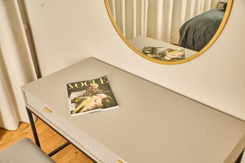 a mirror over a white table with a book on it at Babichy 29 DOM Apartamenty MANDORIA , Rodzina , Family , Orientarium , PTAK , Parking bezpłatny in Babichy