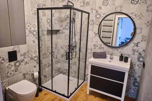 a bathroom with a shower and a sink and a mirror at Babichy 29 DOM Apartamenty MANDORIA , Rodzina , Family , Orientarium , PTAK , Parking bezpłatny in Babichy