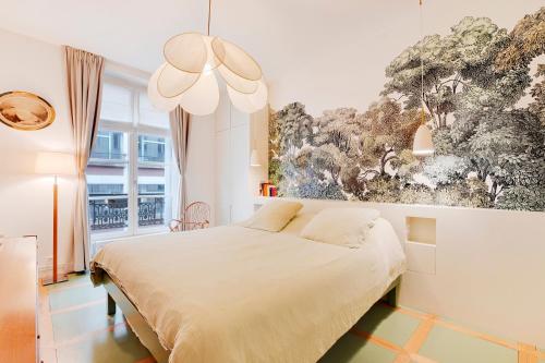 une chambre avec un lit et un tableau au mur dans l'établissement Appartement spacieux et élégant - Grds Boulevards, à Paris