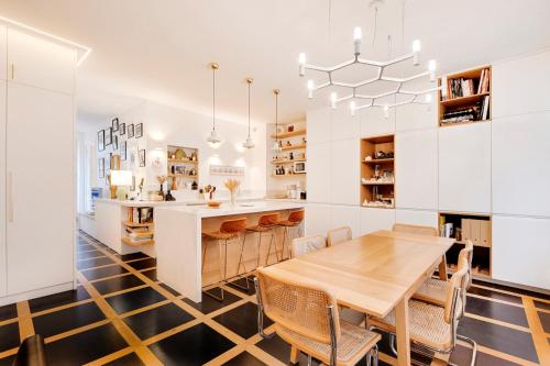 une salle à manger avec une table et des chaises et une cuisine dans l'établissement Appartement spacieux et élégant - Grds Boulevards, à Paris