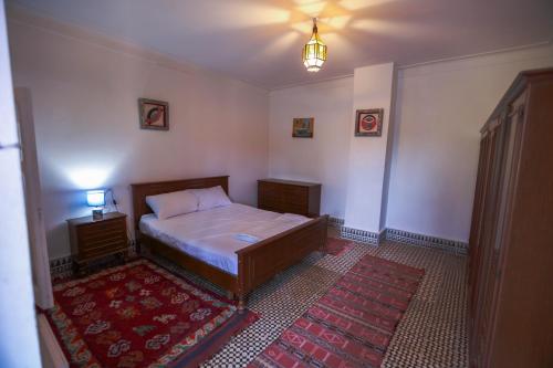 a bedroom with a bed and a red rug at Riad Isla in Essaouira