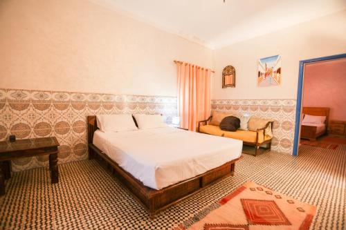 a bedroom with a bed and a couch in it at Riad Isla in Essaouira