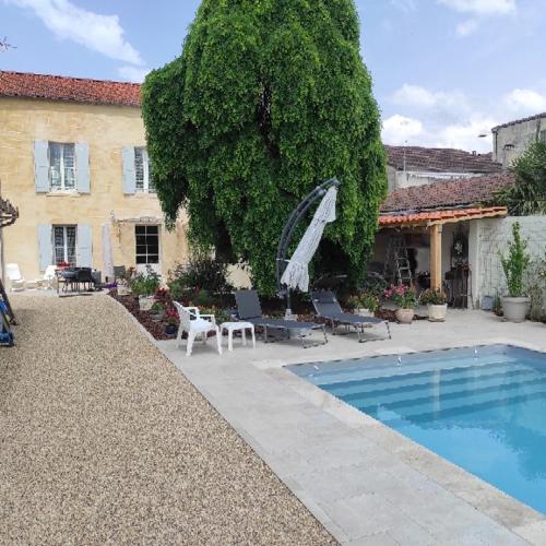 une maison avec une piscine devant une maison dans l'établissement L'Acacia, à Bergerac