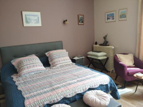 une chambre avec un lit avec une couverture dessus dans l'établissement L'Acacia, à Bergerac