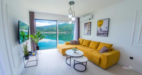 sala de estar con sofá amarillo y ventana grande en Royal Terrace Apartments, en Konjic