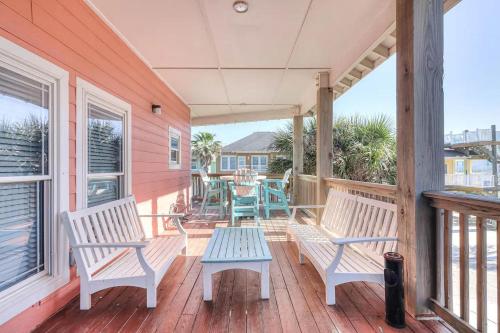 a porch with two benches and a table on it at 6BDRM Beach Home - Oceanviews - Recently Renovated - Shared Pool & HotTub in Port Aransas