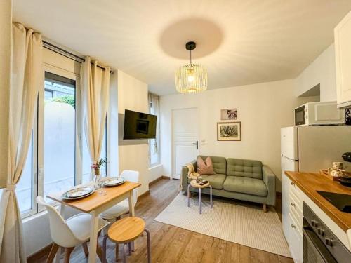 un salon avec un canapé vert et une table dans l'établissement Confortable T2 - Plein Centre, à Tarbes