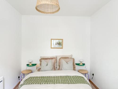 - une chambre blanche avec un lit et 2 tables dans l'établissement Confortable T2 - Plein Centre, à Tarbes