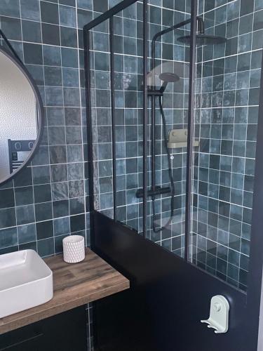 une salle de bain carrelée bleue avec un lavabo et une douche dans l'établissement Villa, à Piedigriggio
