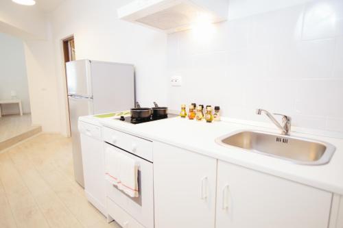 a white kitchen with a sink and a refrigerator at Mountain Apartments SuperSki in Cavnic