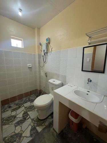 a bathroom with a toilet and a sink at Juanito's Resort in Tangalan