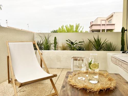 une table avec des verres et une chaise sur un balcon dans l'établissement Joli T2 Ensoleillé & Calme - Terrasse vue sur Parc, à Montpellier