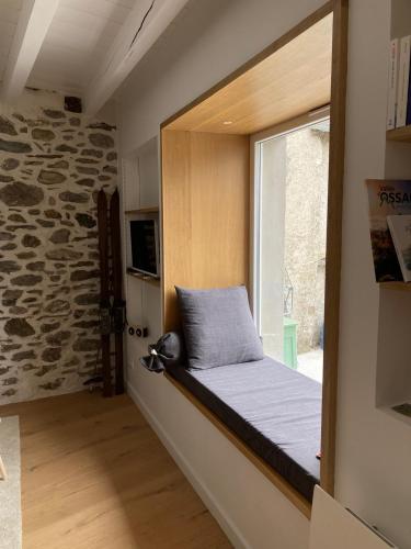un lit dans une chambre avec une fenêtre dans l'établissement Au Graé - Maison à louer à Laruns Béarn, à Laruns