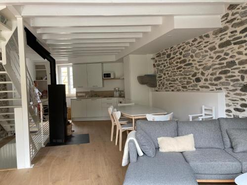 a living room with a blue couch and a stone wall at Au Graé - Maison à louer à Laruns Béarn in Laruns