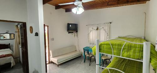 a bedroom with a bunk bed with a green blanket at Cabaña el rincón de Termas in Termas de Río Hondo
